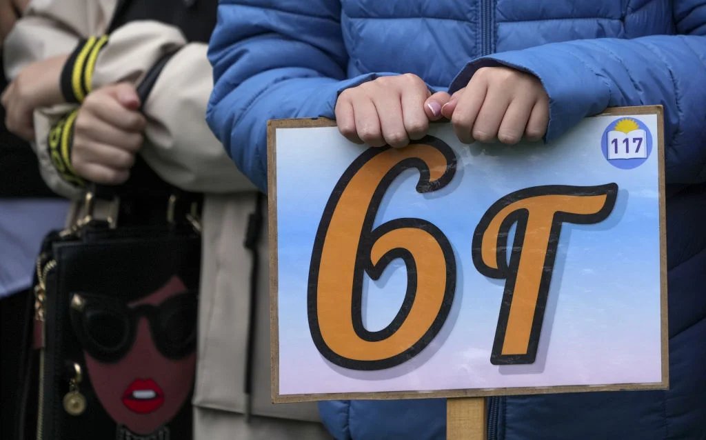 A child holding a sign ‘Grade 6G’ at a school assembly. Photo: Pavel Pavlov/Anadolu Agency via Getty Images