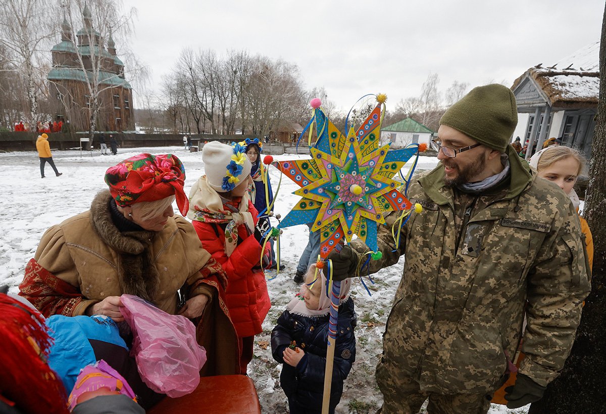 Военнослужащий территориальных сил обороны Украины держит «Вифлеемскую звезду» во время празднования Рождества в селе Пирогово, недалеко от Киева, 25 декабря 2023 года. Фото: Сергей Долженко / EPA-EFE