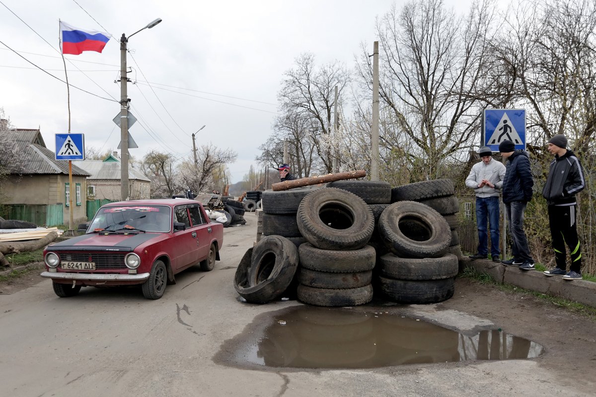 Автомобиль проезжает мимо блокпоста пророссийских протестующих на дороге в селе Дружковка Донецкой области недалеко от Славянска, 14 апреля 2014 года. Фото: Анастасия Власова / EPA