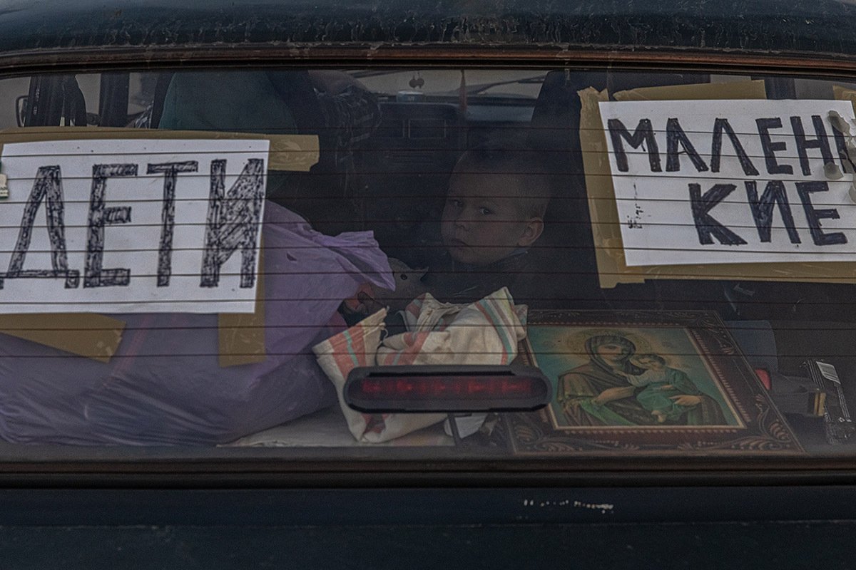 Дети ожидают в машине после прибытия из Мариуполя в пункт эвакуации в Запорожье, Украина, 2 мая 2022 года. Фото: Роман Пилипей / EPA-EFE