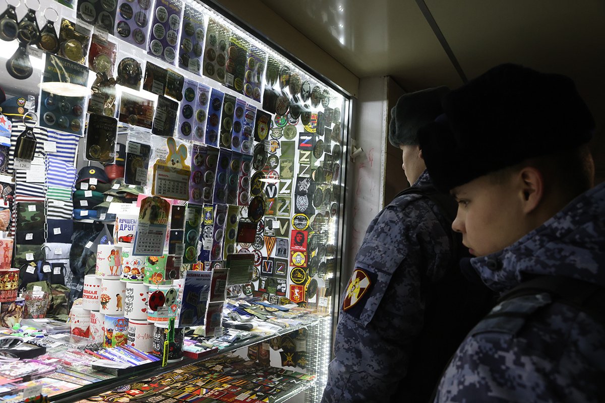 Военнослужащие войск национальной гвардии РФ рассматривают значки «Z» и «V» в магазине в подземном переходе 2 апреля 2023 года в Москве. Фото: Contributor / Getty Images