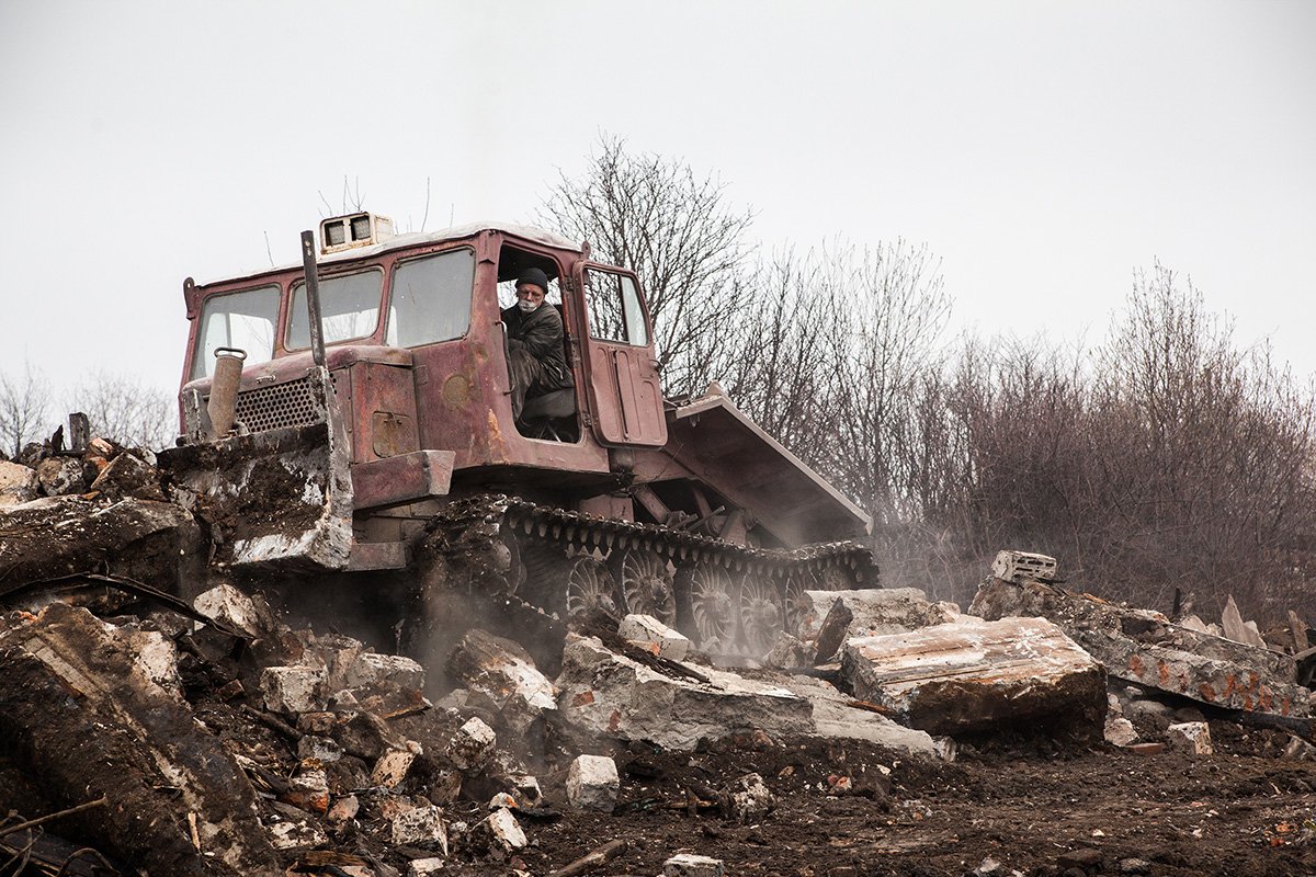 Грейдер ровняет с землей то, что осталось от дома. Фото: Николай Кожевников, специально для «Новой газеты Европа»