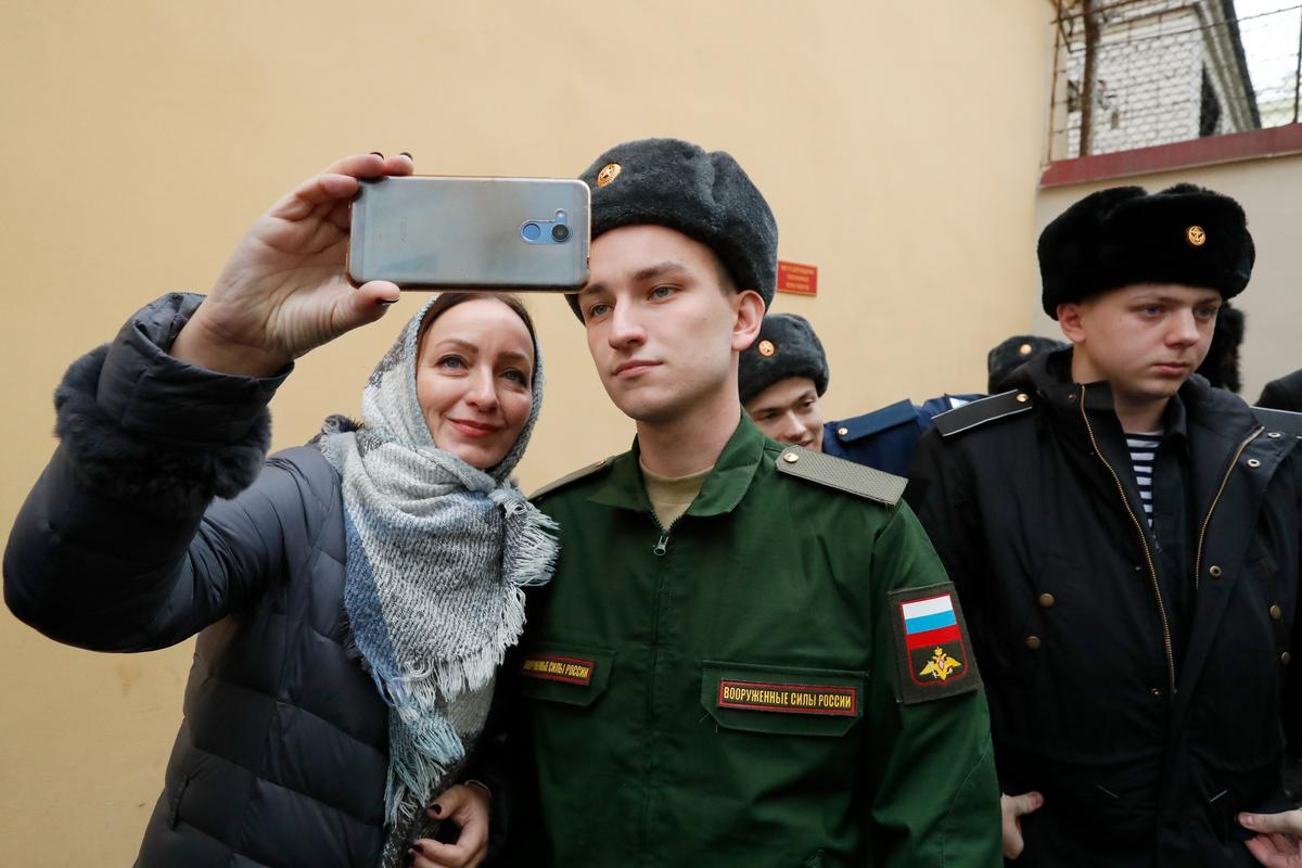 A young Russian recruit bids farewell to his family in St. Petersburg. Photo: EPA-EFE / ANATOLY MALTSEV