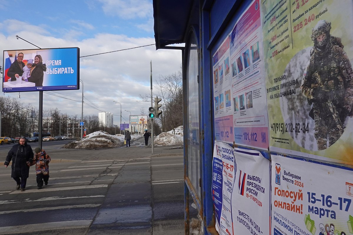 Билборд «Время выбирать» на фоне доски объявлений с рекламой выборов и контрактной службы в армии в Москве. Фото: Максим Шипенков / EPA-EFE