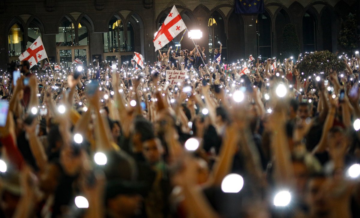 Противники закона, участвуя в акции, включили фонарики на телефонах, 1 мая. Фото: David Mdzinarishvili / EPA-EFE