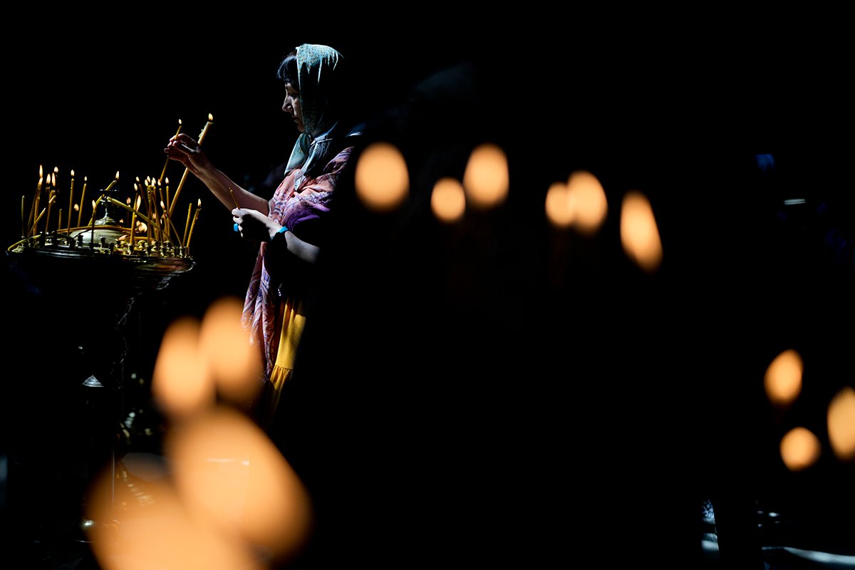 Женщина зажигает свечу в Свято-Владимирском соборе во время празднования православной Пятидесятницы в Киеве, Украина, в воскресенье, 12 июня 2022 года. Фото: Natacha Pisarenko / AP / Scanpix / LETA