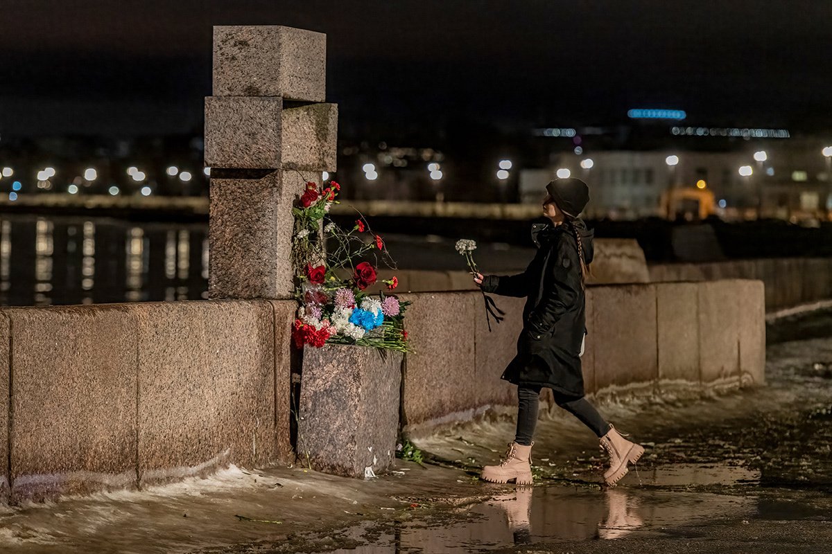Женщина несет цветы к памятнику жертвам политических репрессий, чтобы почтить память Алексея Навального, Санкт-Петербург, 17 февраля 2024 года. Фото: Андрей Бок / SOPA Images / LightRocket / Getty Image