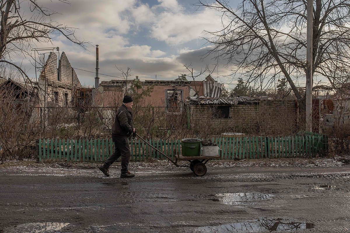 Местный житель Лимана идет с тележкой угля мимо разрушенных домов, Лиман Донецкая область, 21 января 2024 года. Фото: Роман Пилипей / AFP / Scanpix