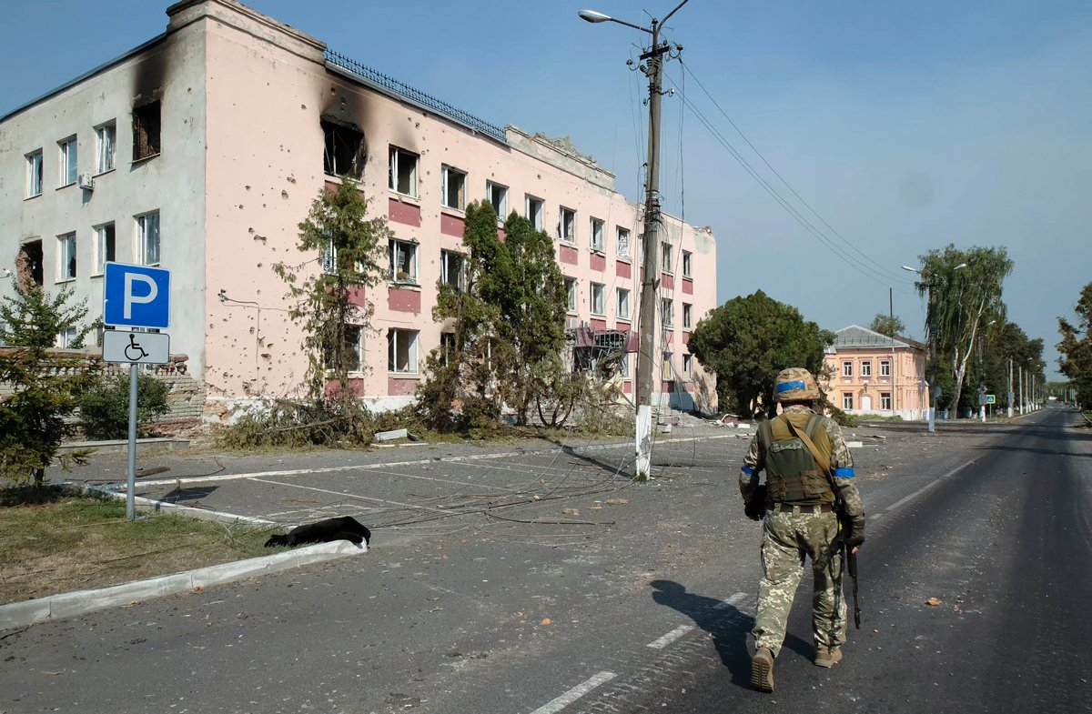 Украинский военнослужащий на фоне поврежденных зданий в центре Суджи, Курская область, 21 августа 2024 года. Фото: EPA-EFE