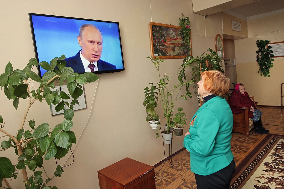 Пенсионерка в доме престарелых в Симферополе смотрит выступление Владимира Путина во время ежегодного прямого эфира, 17 апреля 2014 года. Фото: Артур Шварц / EPA