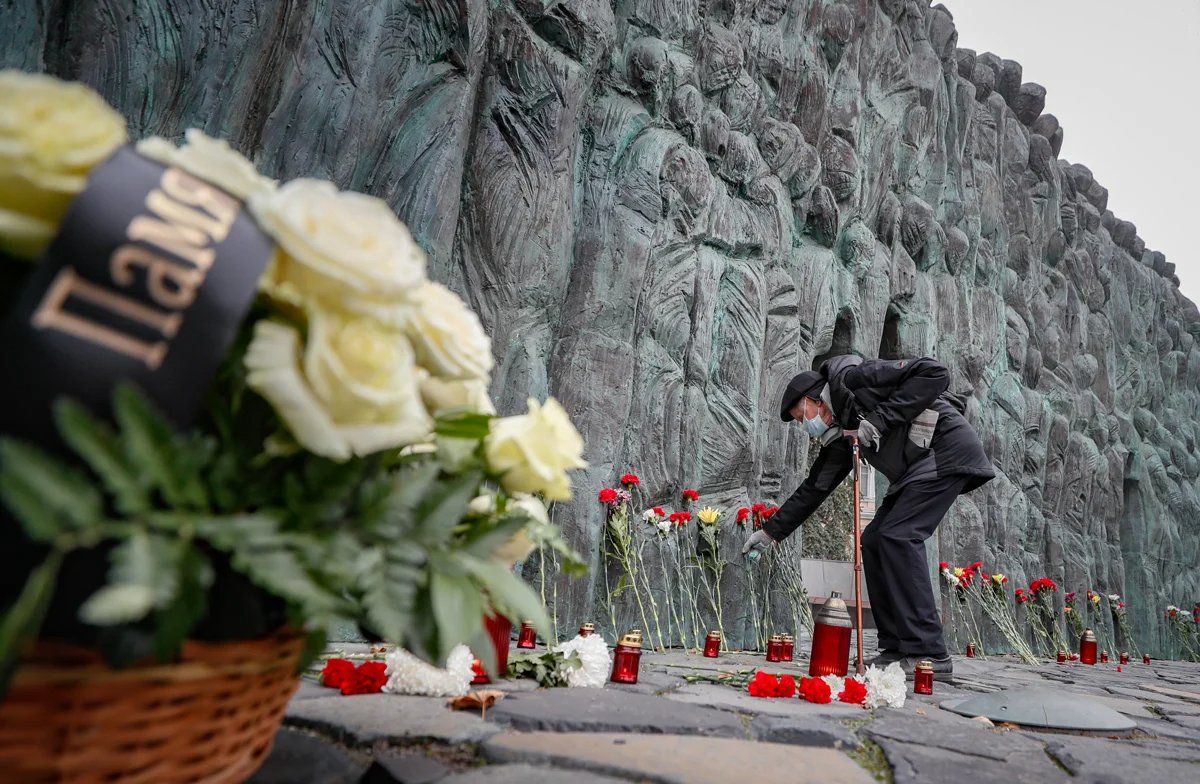 A man lays flowers at the Wall of Grief in Moscow, 30 October 2022. Photo: Yury Kochetkov / EPA-EFE