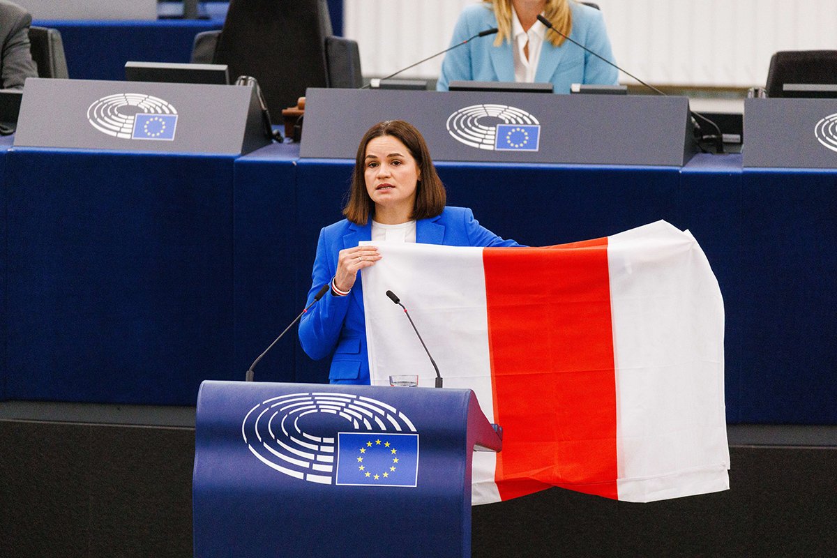 Sviatlana Tsikhanouskaya holding up a white-red-white flag, the historical flag of Belarus, during a session of the European Parliament in Strasbourg. Photo: Philipp von Ditfurth / picture alliance / Getty Images