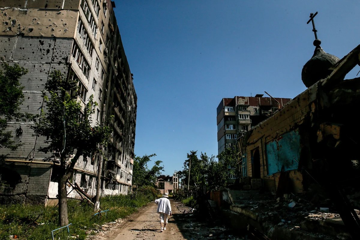 A woman walks along the ruins of a street in Vuhledar, July 2023. Photo: Oleh Petrasiuk / EPA-EFE