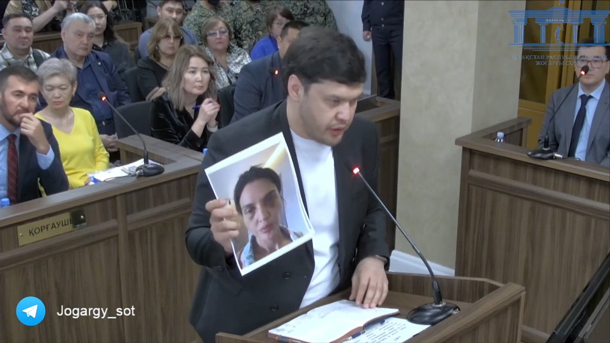 Брат Салтанат Нукеновой Айтбек Амангельды в суде показывает фото избитой сестры, которое она отправила ему. Фото: Верховный суд Республики Казахстан / YouTube