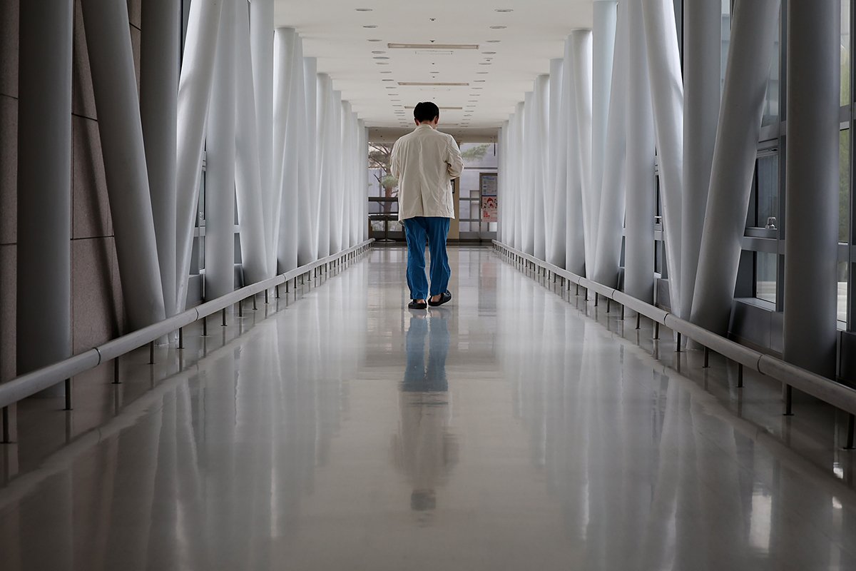 Медицинский работник идет по коридору больницы в Сеуле, Южная Корея, 10 апреля 2024 года, на фоне продолжающегося противостояния между правительством и врачами по поводу плана увеличения квоты на поступление в медицинские школы. Фото: Yonhap South Korea / EPA-EFE