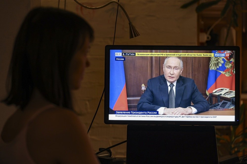 A woman watches Vladimir Putin’s televised address in which he announced the ballistic missile strike on Ukraine on 21 November. Photo: EPA-EFE/SERGEI ILNITSKY