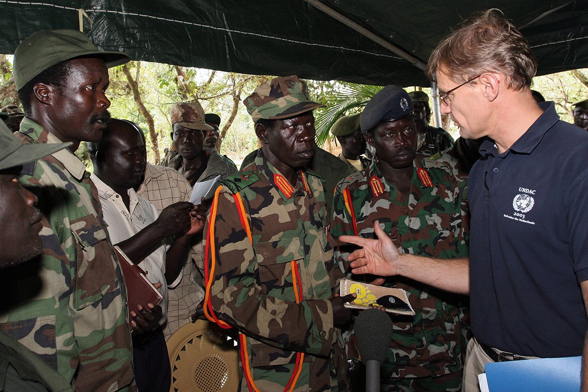 Лидер «Армии сопротивления Господа» Джозеф Кони (слева) и его заместитель Винсент Отти (справа) беседуют с главой гуманитарной миссии ООН Яном Эгеланном в воскресенье, 12 ноября, в Ри-Квамбе на Юге Судана. Фото: Stuart Price / EPA