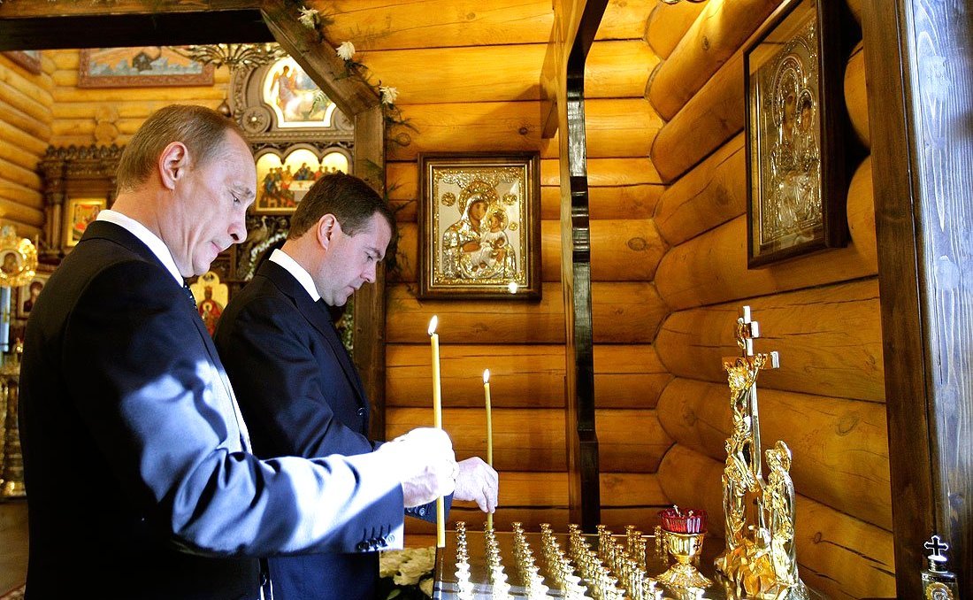 Владимир Путин и Дмитрий Медведев ставят свечи в часовне на территории резиденции главы государства в память о погибших в катастрофе под Смоленском. Фото:  Wikimedia Commons , CC BY 4.0