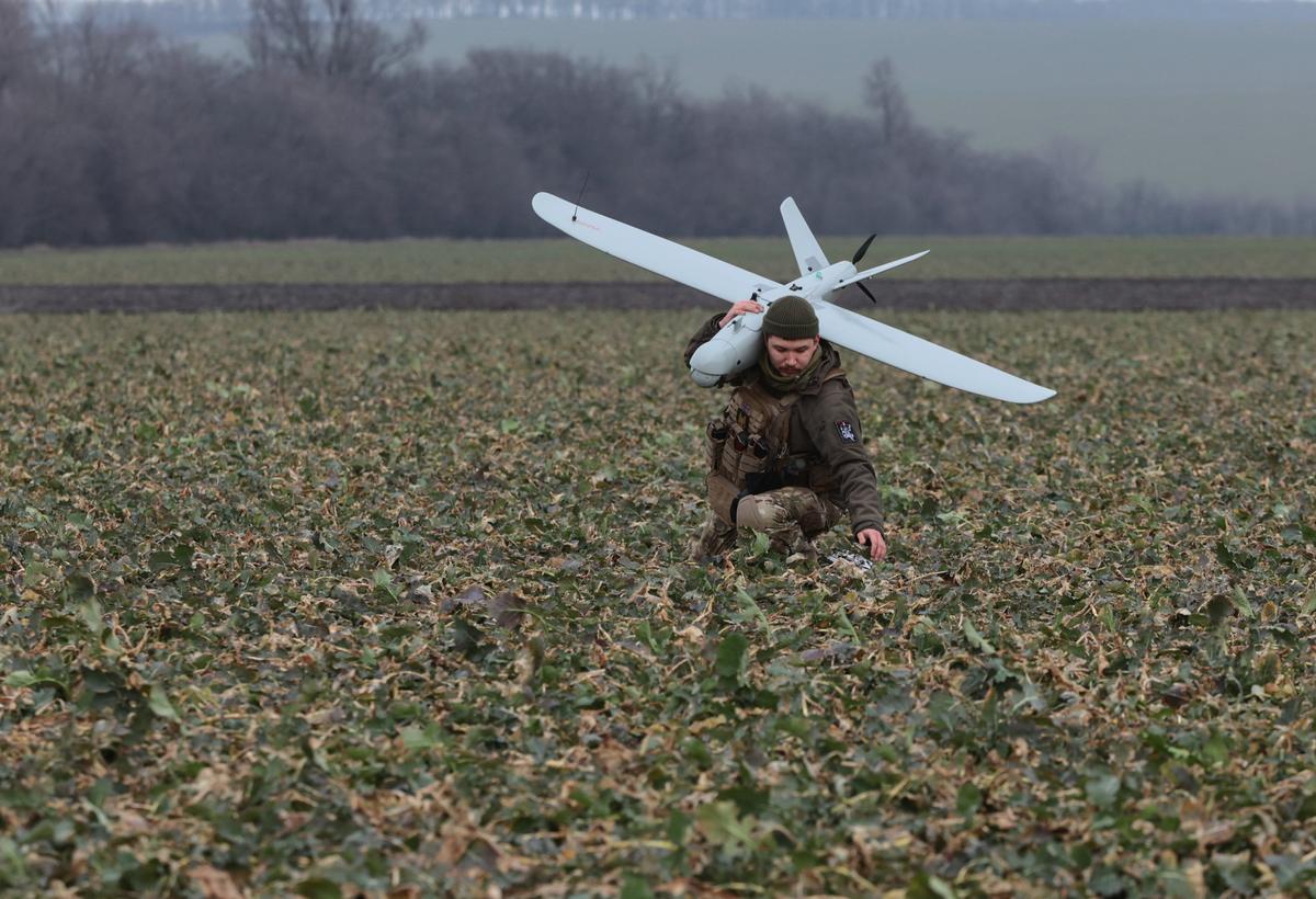 A Ukrainian serviceman carries a multi-purpose drone through a field near the frontline in southeastern Ukraine’s Zaporizhzhia region, 15 February 2024. Photo: EPA-EFE / KATERYNA KLOCHKO