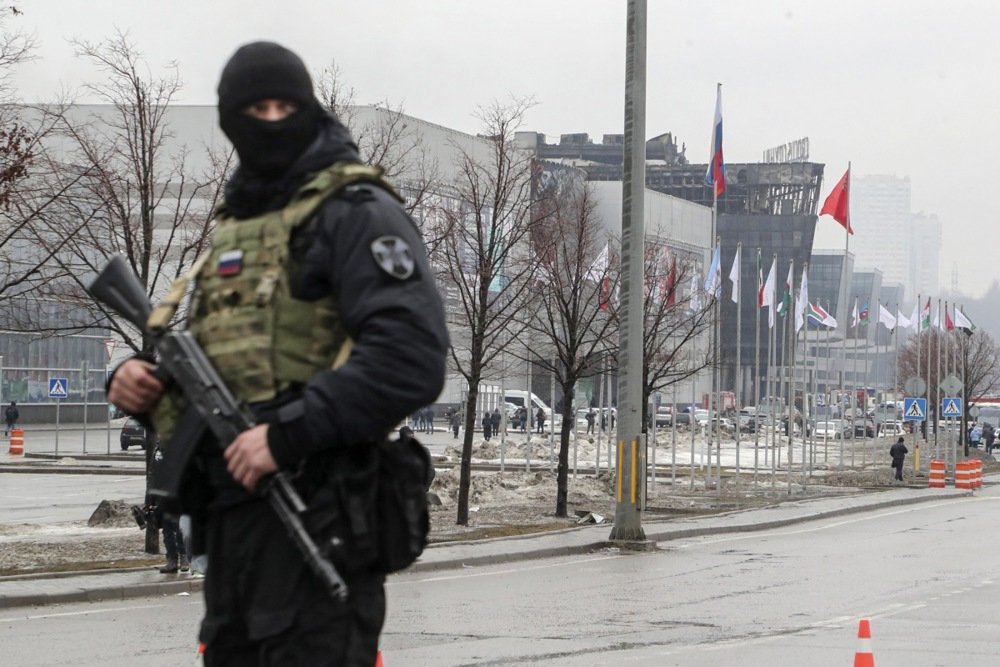 An armed policeman stationed near the burned out concert venue. Photo: EPA-EFE/MAXIM SHIPENKOV