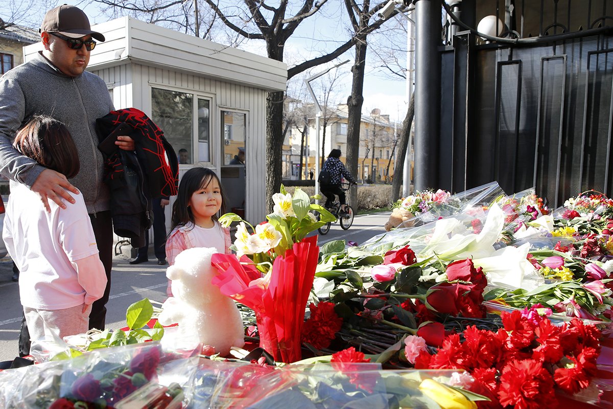 Люди возлагают цветы перед посольством России в память о жертвах теракта в Крокус Сити Холле. Бишкек, Кыргызстан, 23 марта 2024 года. Фото: Игорь Коваленко/EPA-EFE
