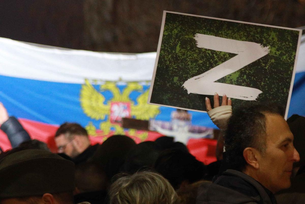 Участники пророссийской акции в Белграде держат плакат с изображением буквы Z, март 2022 года. Фото: Milos Miskov / Anadolu Agency / Getty Images