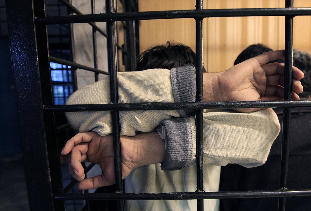 Архивная фотография задержанного мигранта за решеткой. Фото: Илья Наймушин / Reuters / Scanpix / LETA