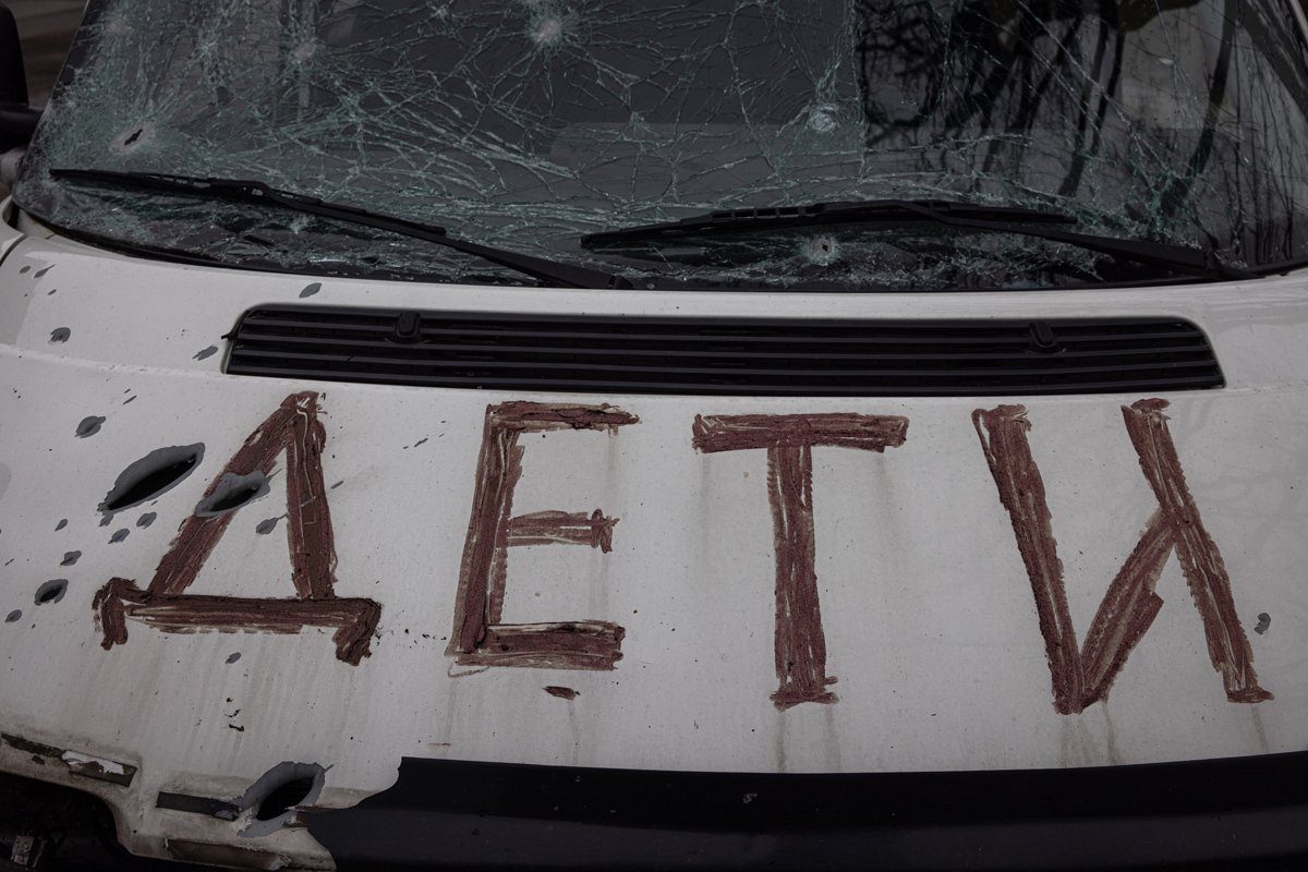 Следы от выстрелов на машине с надписью «Дети» в Буче, 6 апреля 2022 года. Фото: Роман Пилипей / EPA-EFE