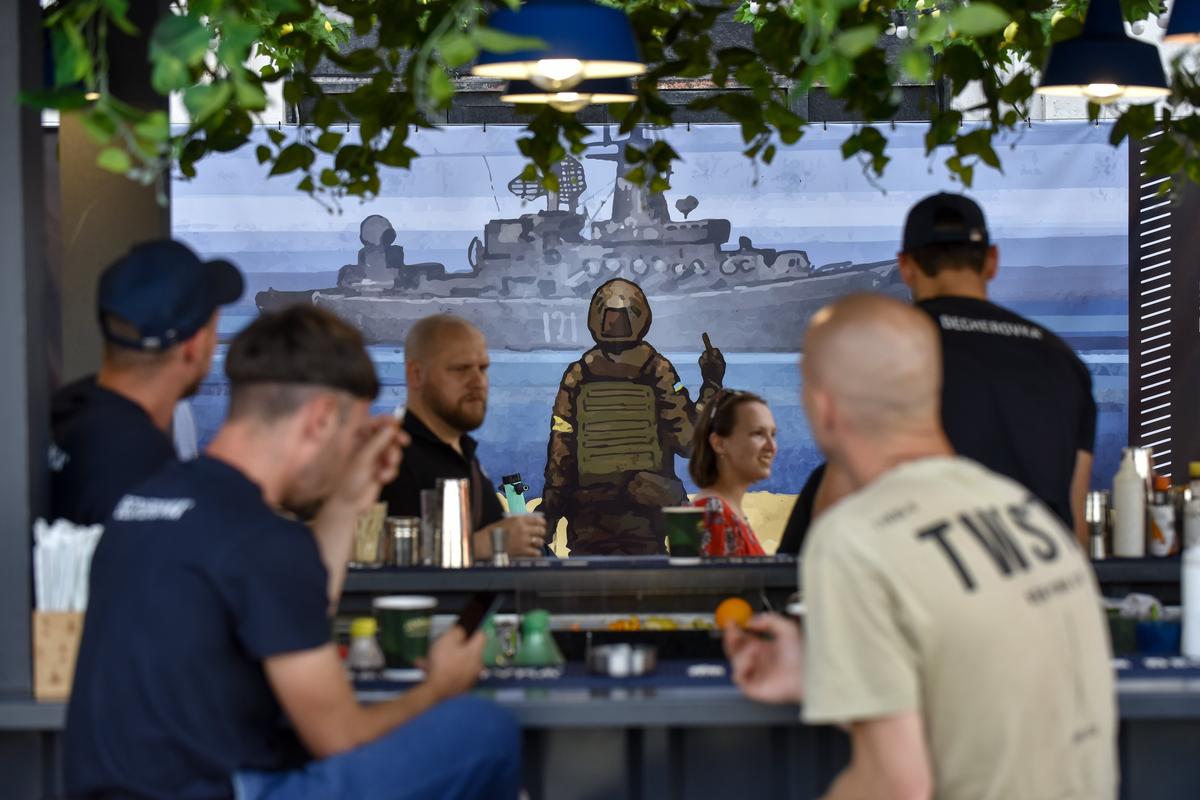 Плакат с изображением украинского солдата, указывающего на российский военный корабль у острова Змеиный, в баре в Киеве. Фото: EPA-EFE/OLEG PETRASYUK