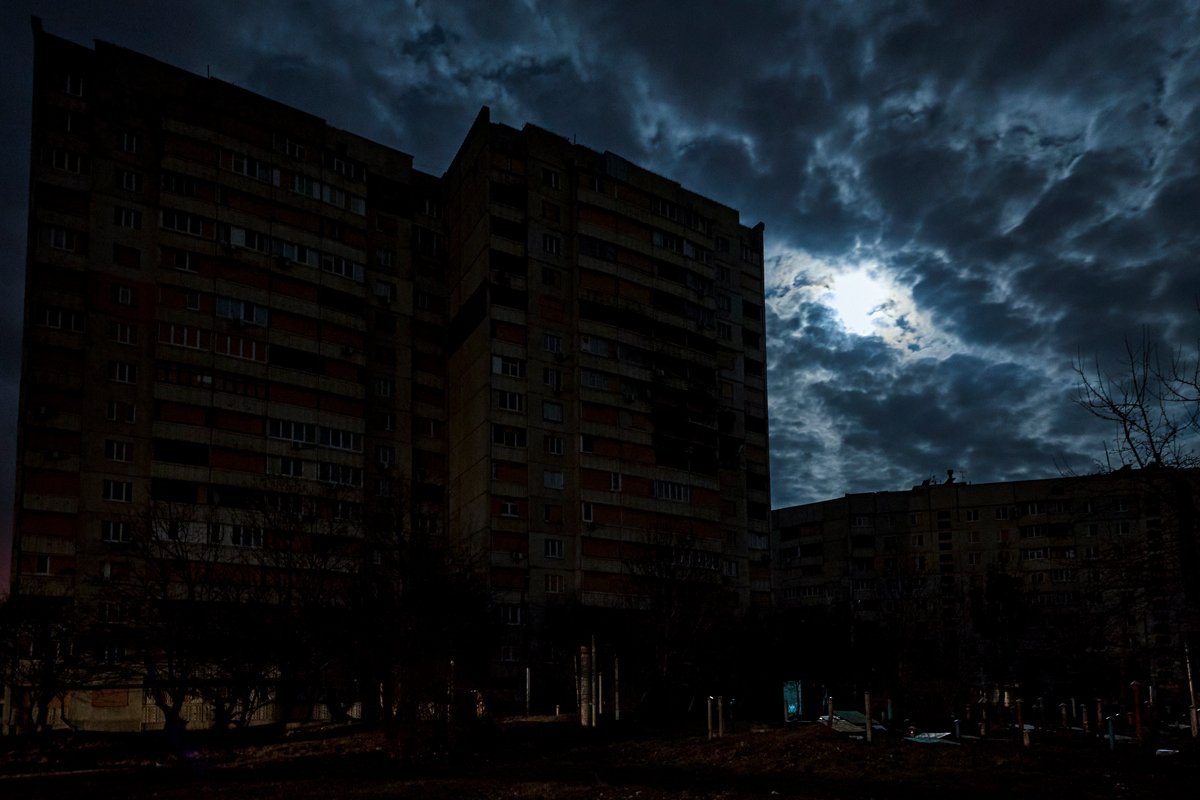Вид на улицу и жилые дома в темноте во время отключения электричества в Харькове, Украина, 24 марта 2024 года. Фото: Сергей Козлов / EPA-EFE