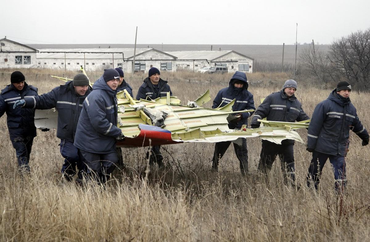 Рабочие убирают части обломков пассажирского самолета MH17 Malaysia Airlines на месте крушения в селе Грабово, примерно в 70 км от Донецка, 18 ноября 2014 г. Фото: EPA/ALEXANDER ERMOCHENKO