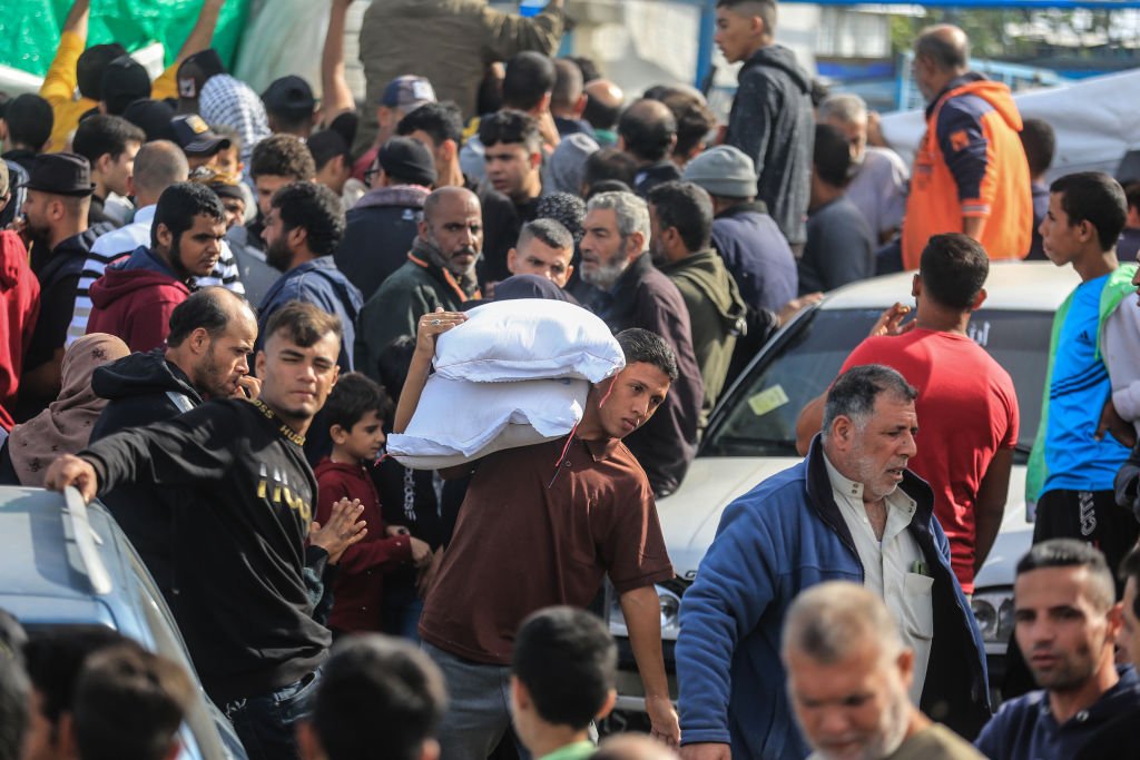 Палестинцы получают мешки с мукой в распределительном центре Агентства ООН, Хан-Юнис, 22 ноября 2023 года. Фото: Mohammed Talatene / picture alliance / Getty Images