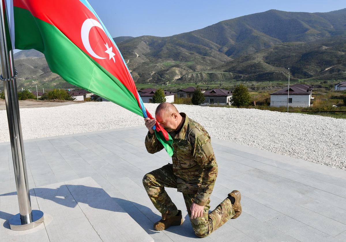 Azerbaijani President Ilham Aliyev hoists the national flag over the recaptured village of Askeran in Nagorno-Karabakh, 15 October 2023. Photo: EPA-EFE / STRINGER