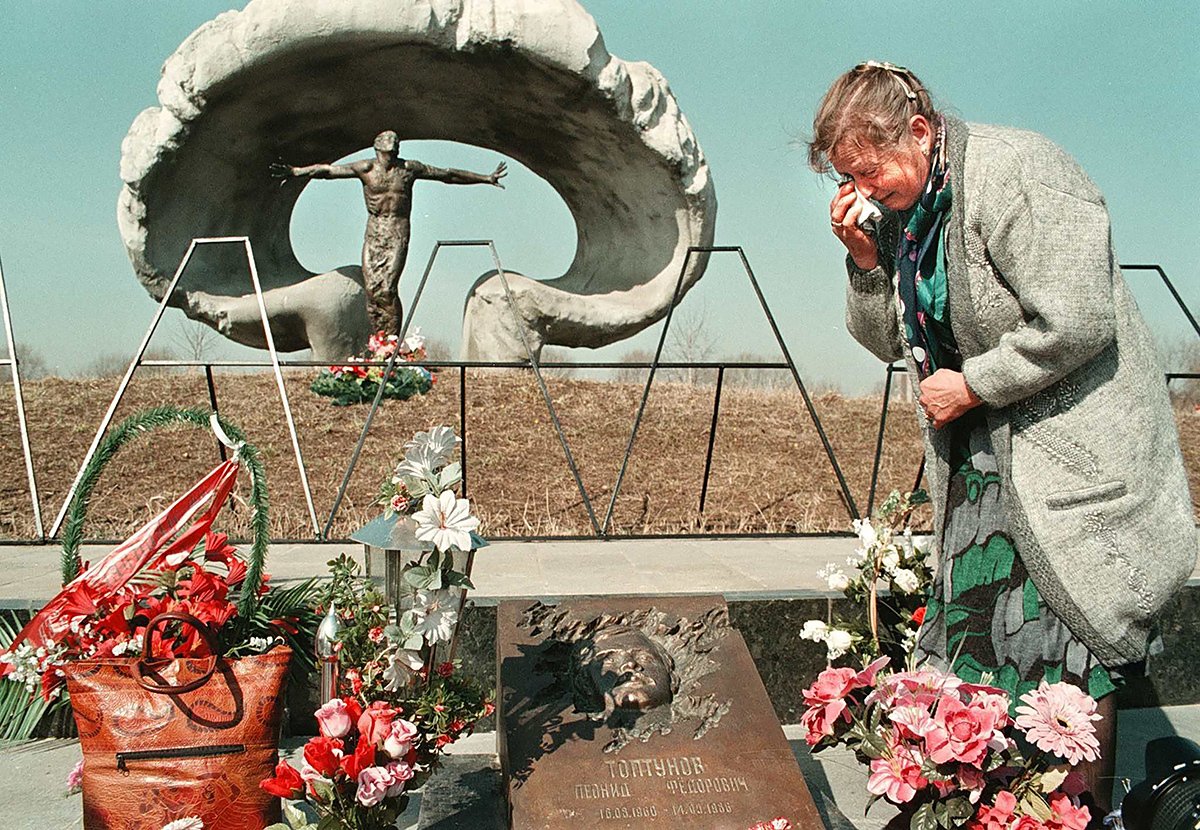 Мать ликвидатора Леонида Топтунова, погибшего во время работ на разрушенной Чернобыльской атомной электростанции, у его могилы в мемориальном комплексе на Митинском кладбище в Подмосковье, 26 апреля 1998 года. Фото: илья питалев / EPA-PHOTO