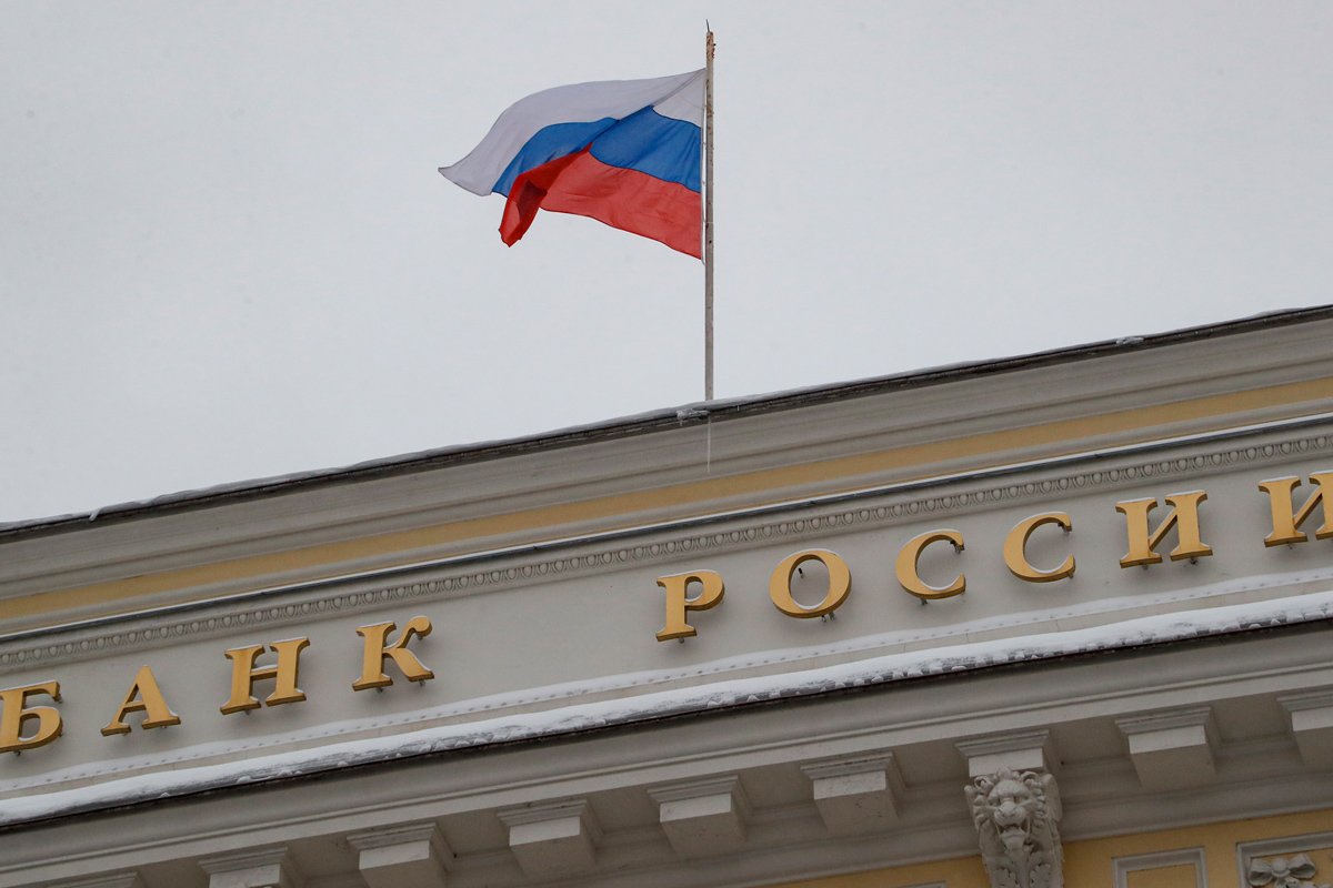 Флаг РФ развевается над вывеской «Банк России» на здании Центрального банка РФ в Москве, 15 декабря 2023 года. Фото: Максим Шипенков / EPA-EFE