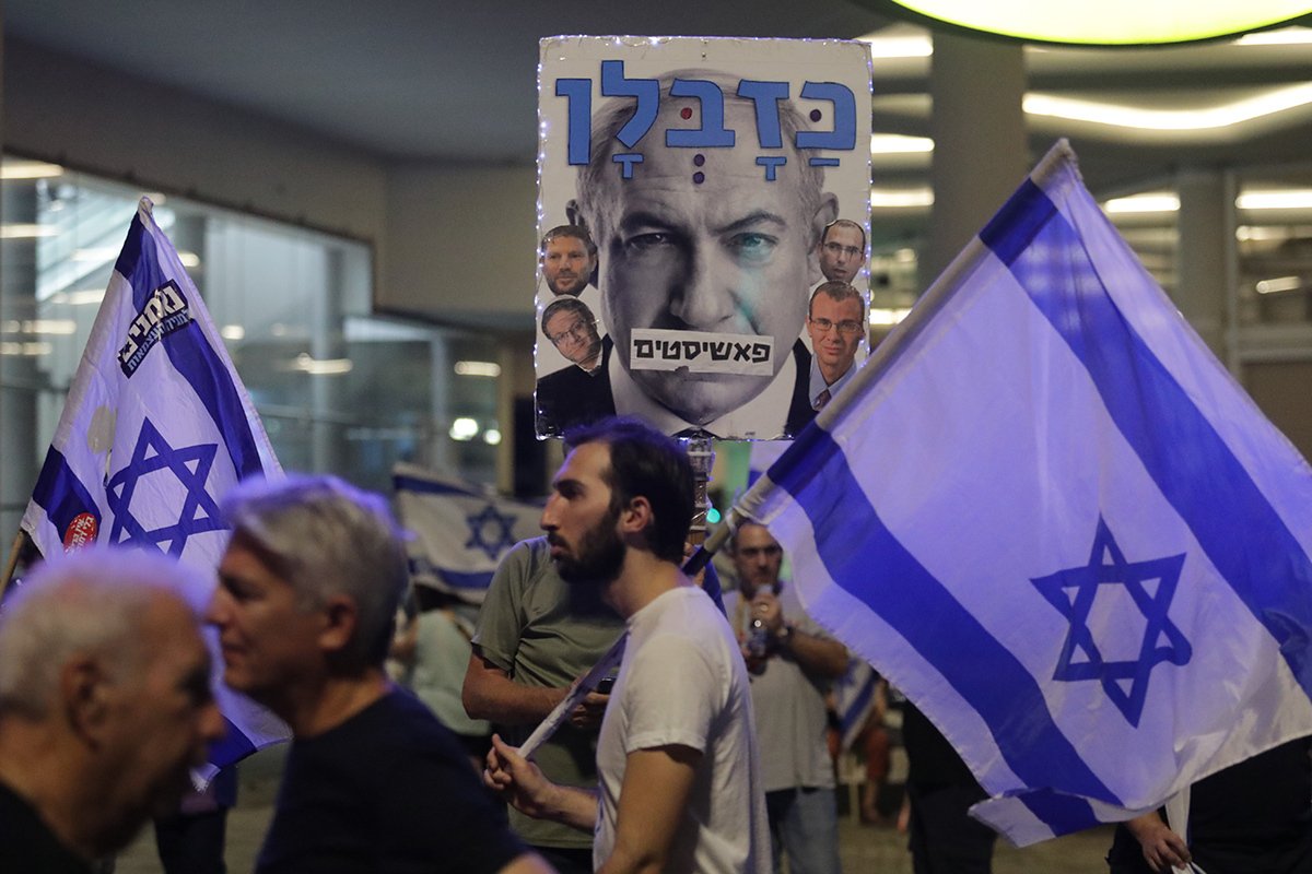 Участники антиправительственной демонстрации держат плакат с изображением премьер-министра Израиля Биньямина Нетаньяху в сентябре 2023. Фото: Abir Sultan / EPA-EFE