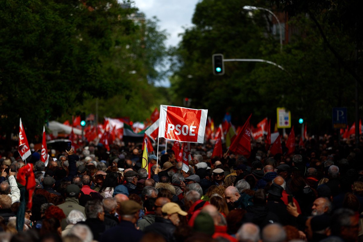 Участник митинга в поддержку премьер-министра Испании держит плакат с логотипом Испанской социалистической партии PSOE у штаб-квартиры партии в Мадриде, Испания, 27 апреля 2024 года. Фото: Rodrigo Jimenez / EPA-EFE