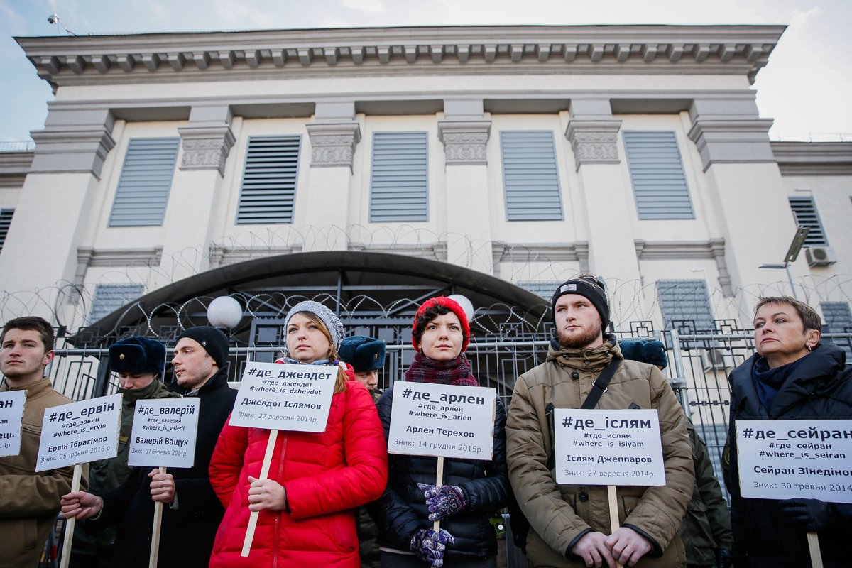 Крымские татары и украинские активисты держат плакаты с именами крымских татар, пропавших без вести в Крыму, 25 октября 2016 года. Фото: Роман Пилипей / EPA