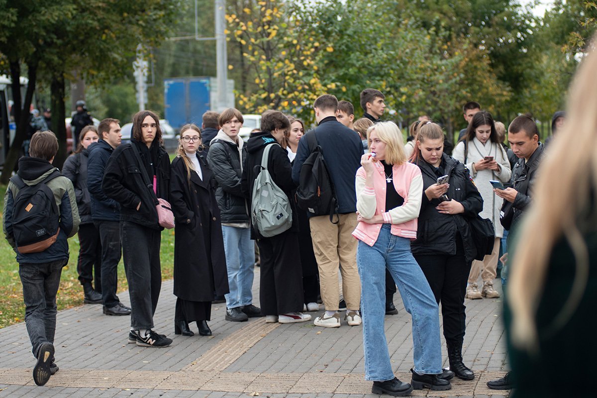 Ученики, эвакуированные из классов из-за стрельбы в школе, стоят на тротуаре перед школой № 88 в Ижевске, Россия, 26 сентября 2022 года. Фото: Андрей Коротков / EPA-EFE