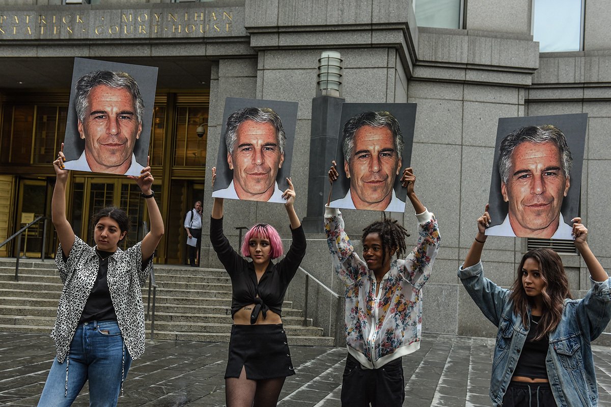 Группа протеста под названием «Hot Mess» держит плакаты с портретом Джеффри Эпштейна перед зданием федерального суда 8 июля 2019 года в Нью-Йорке. Фото: Stephanie Keith/Getty Images