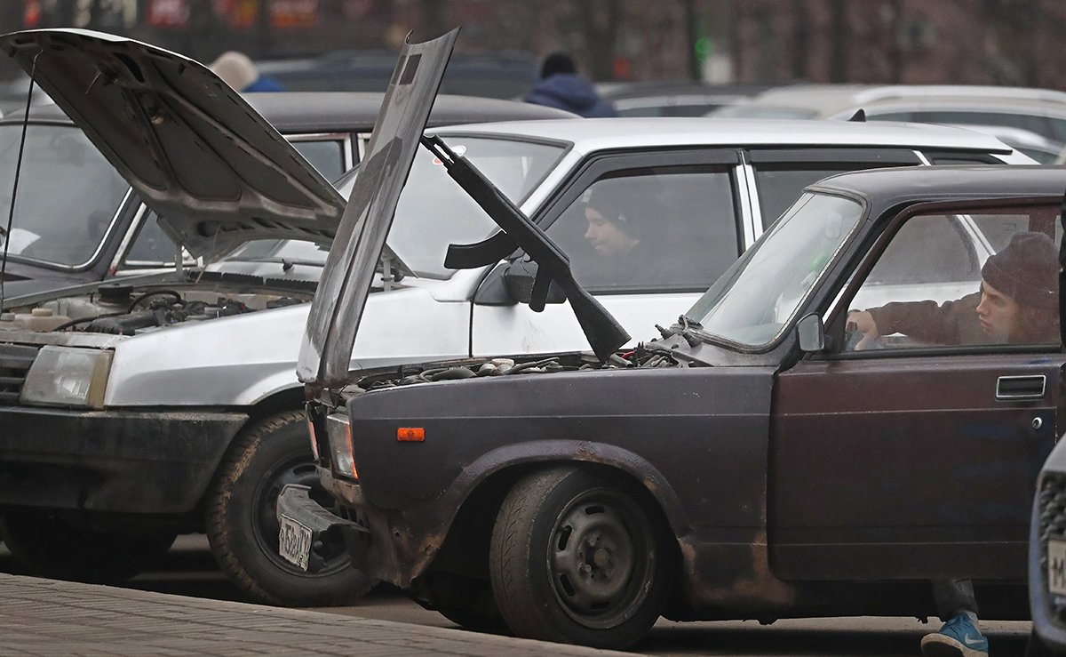 Игрушечный автомат Калашникова держит капот старых «Жигулей», Москва, Россия, 27 ноября 2021 года. Фото: Максим Шипенков / EPA