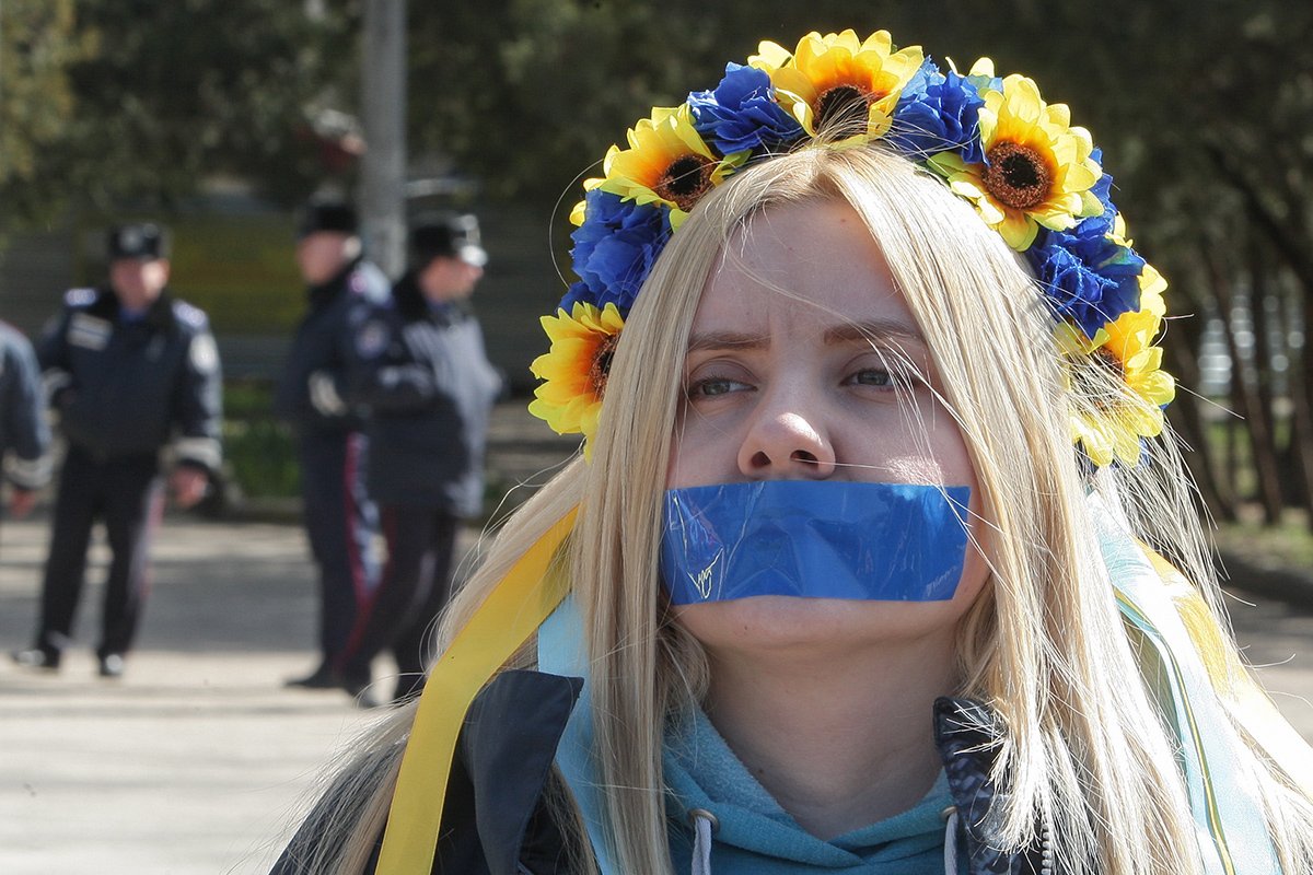 Девушка с заклеенным ртом на митинге в Симферополе, Крым, Украина, 13 марта 2014 года. Фото: Артур Шварц / EPA