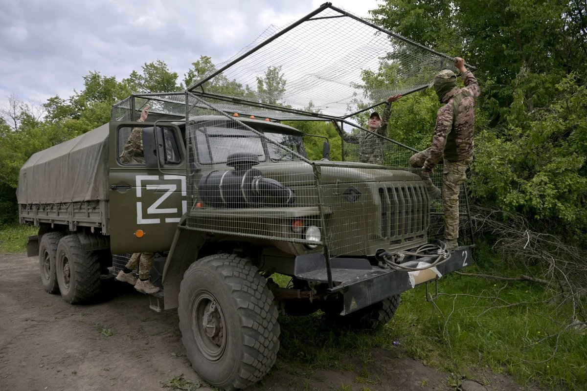 Russian soldiers cover a vehicle with camouflage netting, 16 May, 2024. Photo Evgeny Biyatov / Sputnik / Imago Images / SNA / Scanpix / LETA