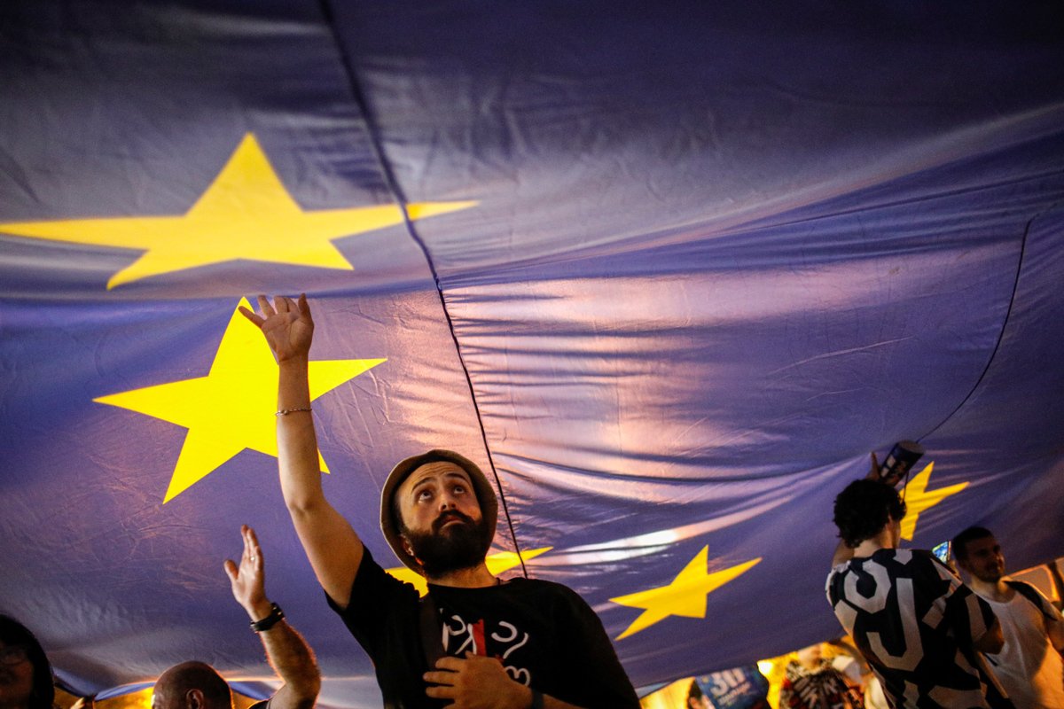 Сторонники оппозиции несут флаг ЕС во время акции протеста против законопроекта об «иностранных агентах» у здания парламента в Тбилиси, 28 апреля 2024 года. Фото: David Mdzinarishvili / EPA-EFE