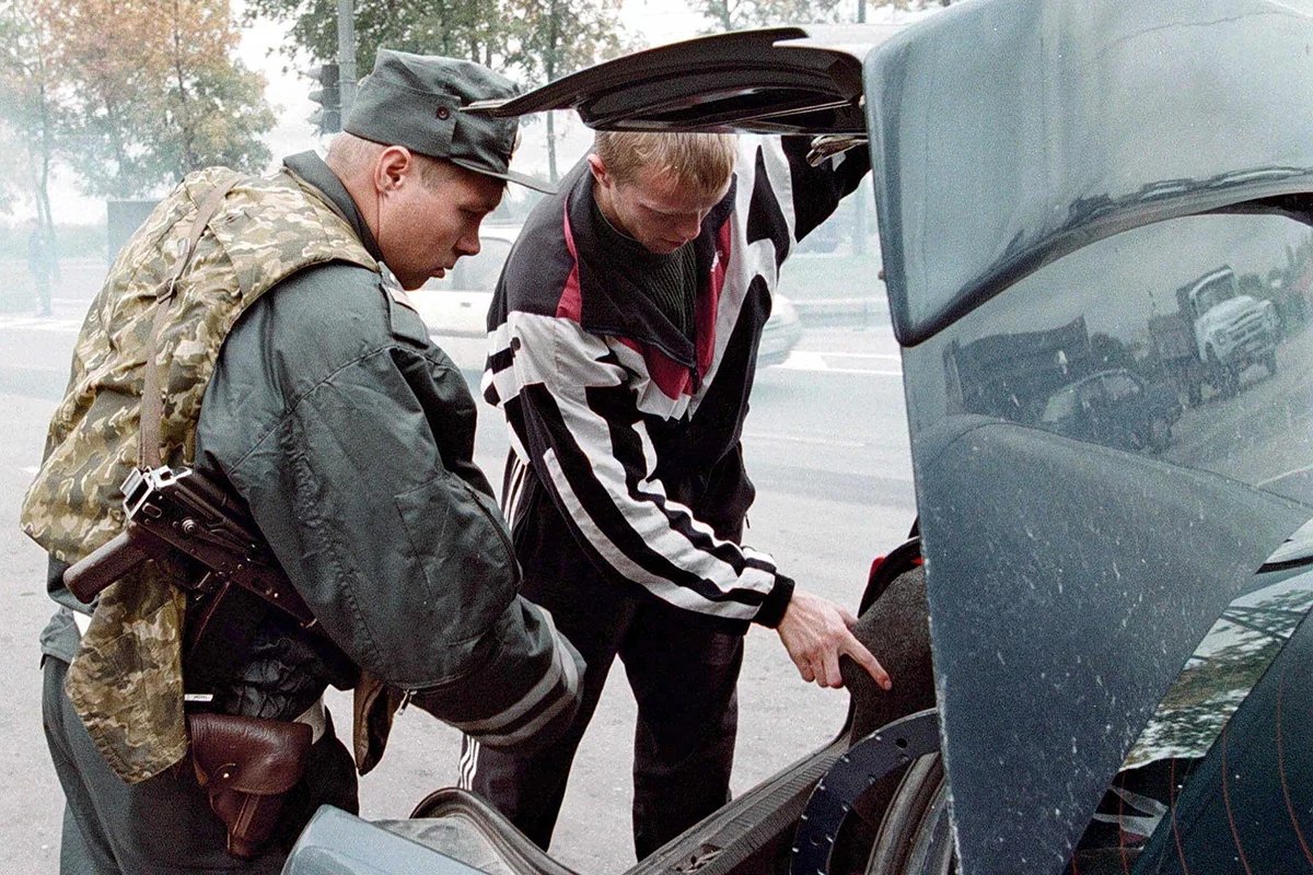 A police officer examining the boot of a car on the road to St. Petersburg, 16 September 1999, following a series of terrorist attacks in Russia. Photo: Anatoly Maltsev/EPA PHOTO/VK