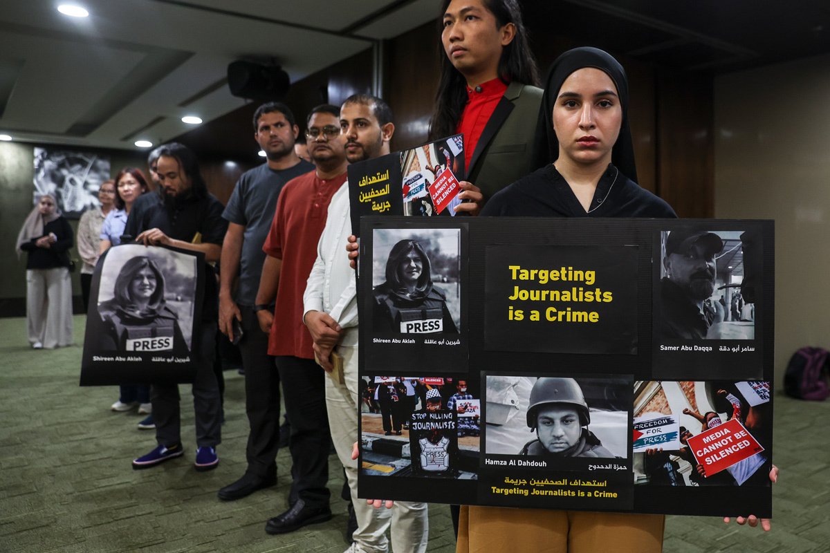 Участники пикета с плакатами «Преследование журналиста — это преступление» и фотографией Хамзы Дахдуха в знак солидарности с палестинскими журналистами, убитыми во время репортажей, приуроченных к Всемирному дню свободы печати в Куала-Лумпуре, Малайзия, 3 мая 2024 года. Фото: Fazry Ismail / EPA-EFE