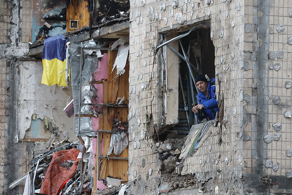 Местный житель смотрит в окно своей разрушенной квартиры в жилом доме, поврежденном российским обстрелом в Киеве, Украина, 5 января 2024 года. Фото: Сергей Долженко / EPA-EFE