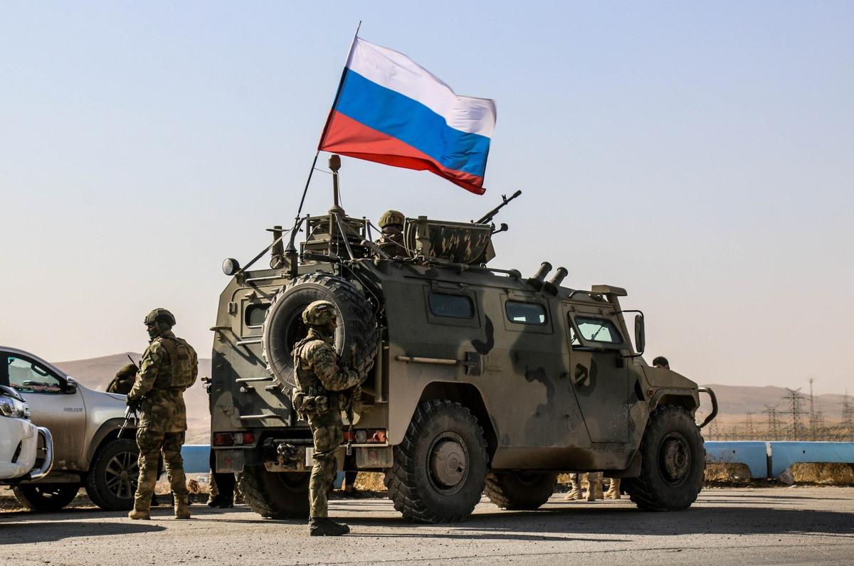 Russian soldiers, with Russian flag, are seen on armoured vehicle as they enter the base at the Tishrin Dam. Photo: Bekir Kasim / Anadolu Agency / Getty Images
