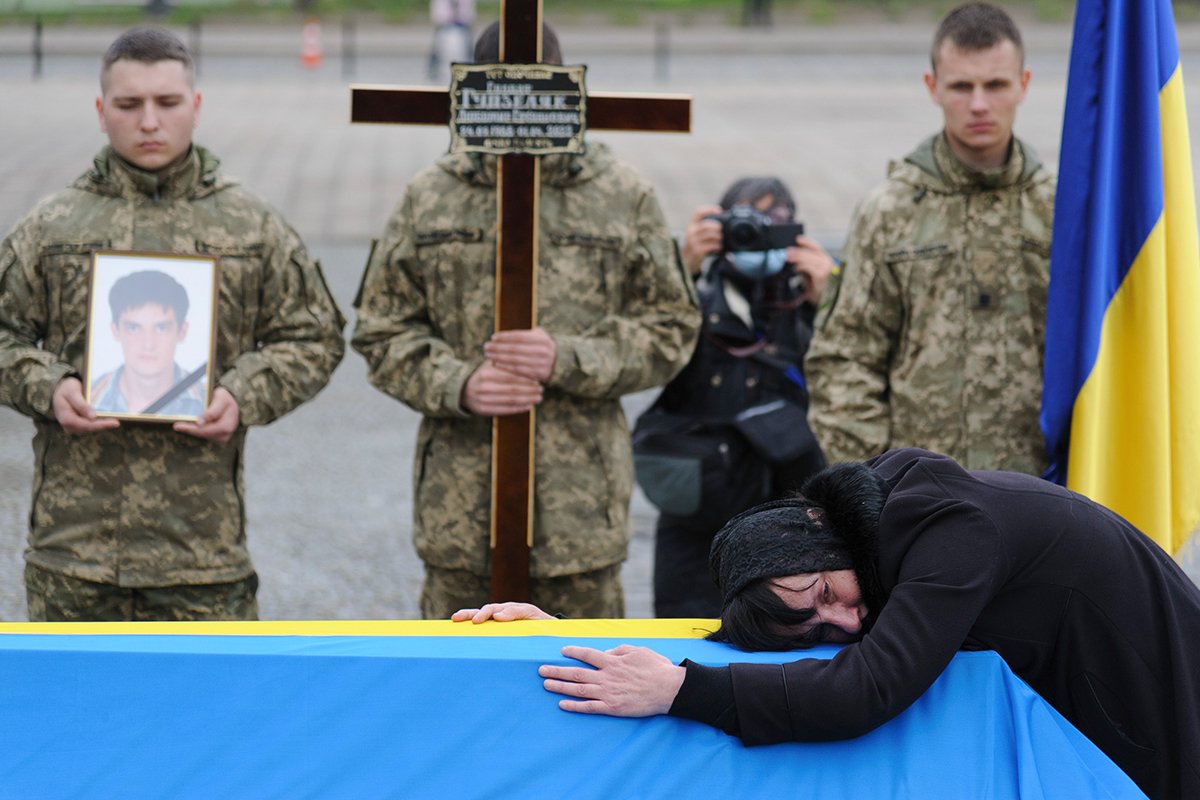 Женщина обнимает гроб украинского военнослужащего, погибшего в бою, во время его похорон во Львове, Украина, 6 апреля 2022 года. Фото: Микола Тыс / EPA-EFE