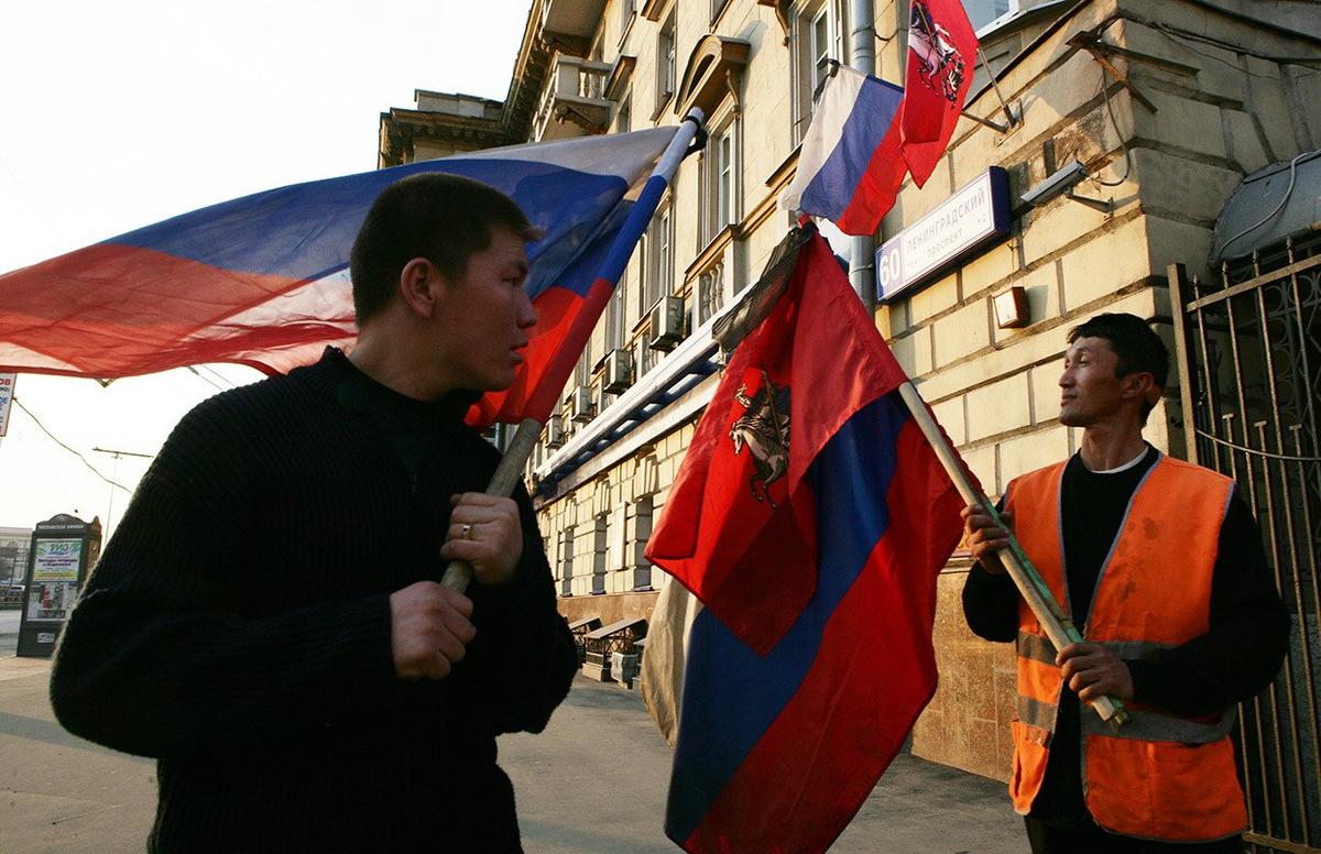 Коммунальные рабочие-мигранты из Киргизии устанавливают российский и московский флаги, 11 апреля 2010 год. Фото: Саша Мордовец/ Getty Images